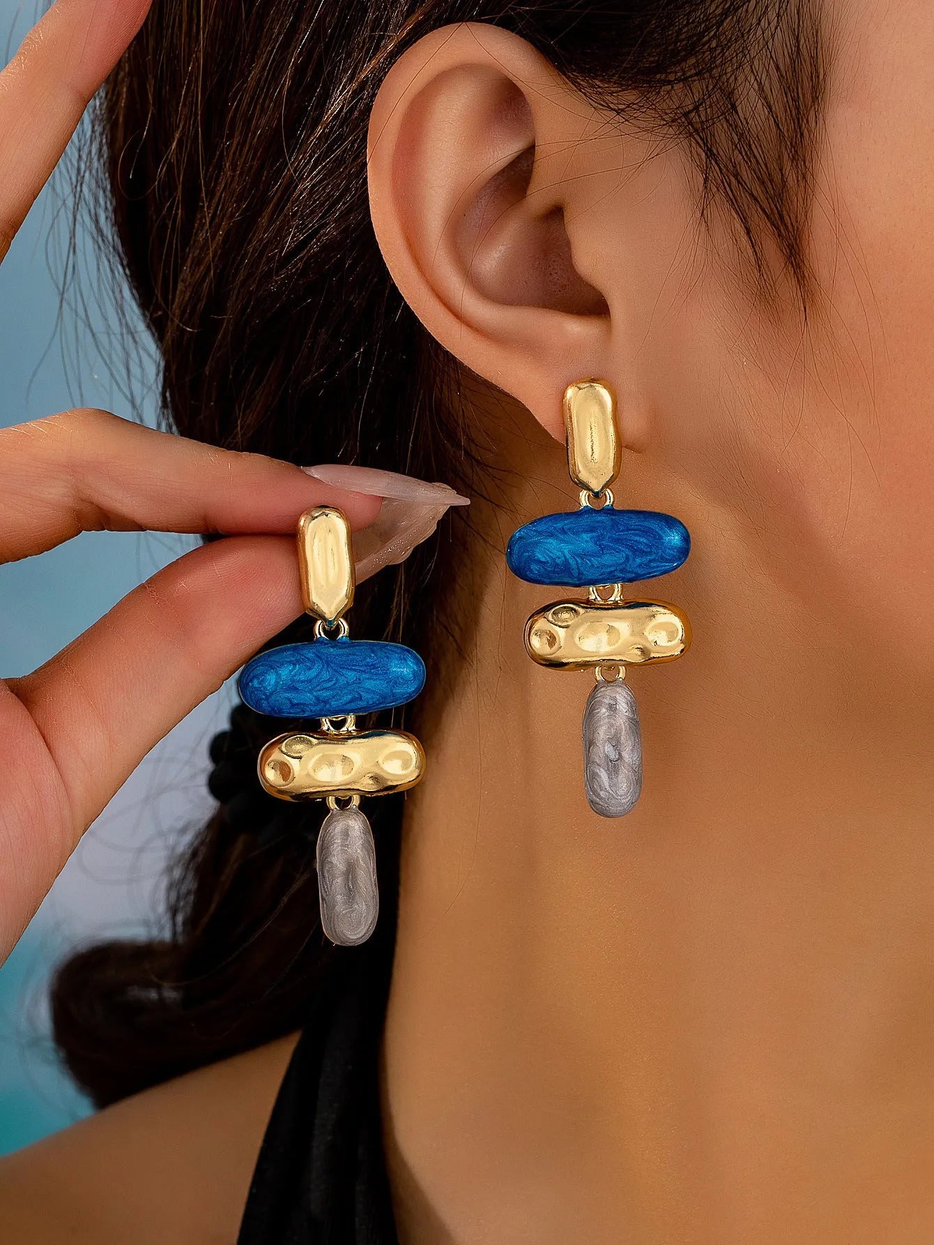 A pair of simple geometric stud earrings with a multicolour electroplated finish on a zinc alloy base.