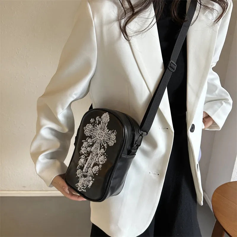 Black mini crossbody bag with Halloween cartoon print of pumpkins, ghosts, and bats.