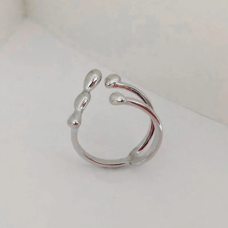 Brass opening ring in gold or silver finish with spherical design details.