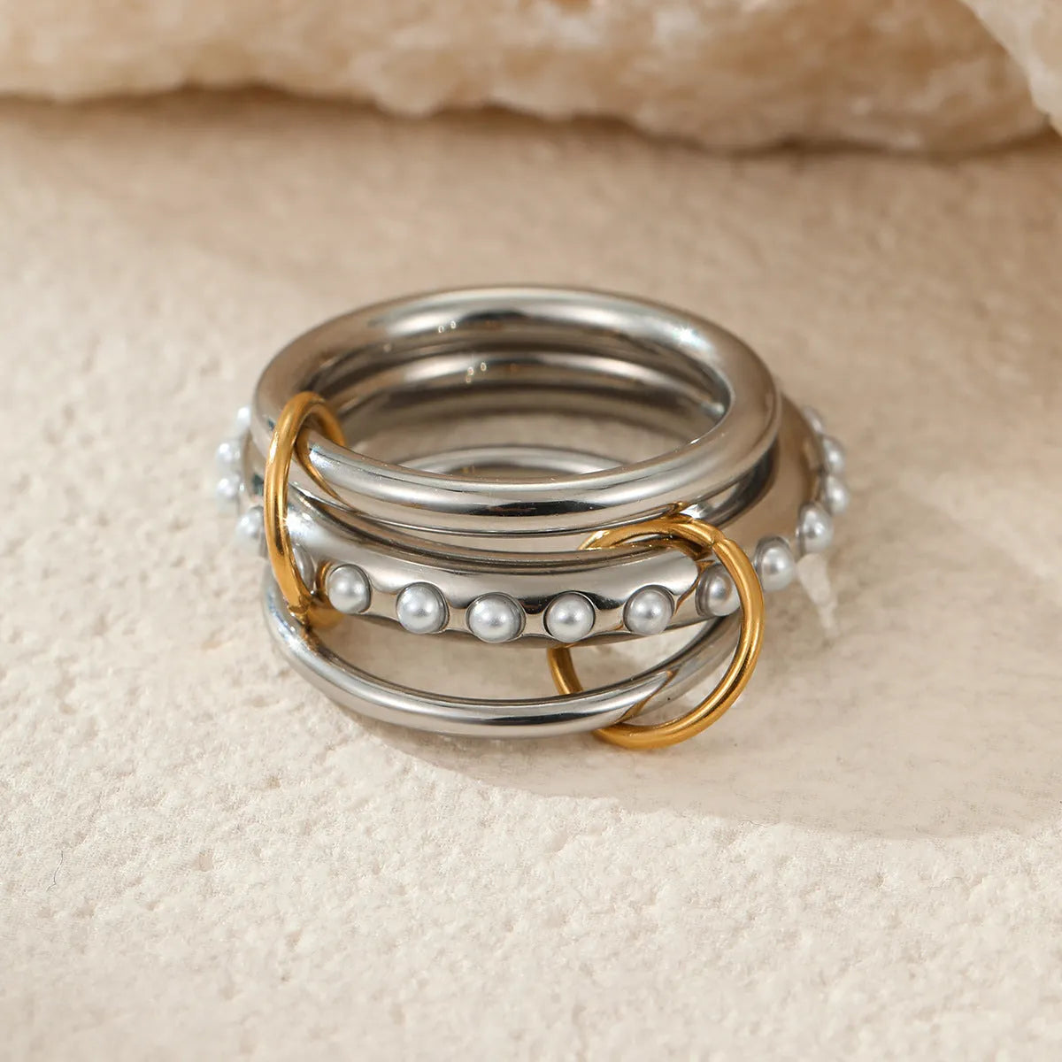 Stacked gold plated stainless steel rings with an exaggerated wide band design, shown in a free size.