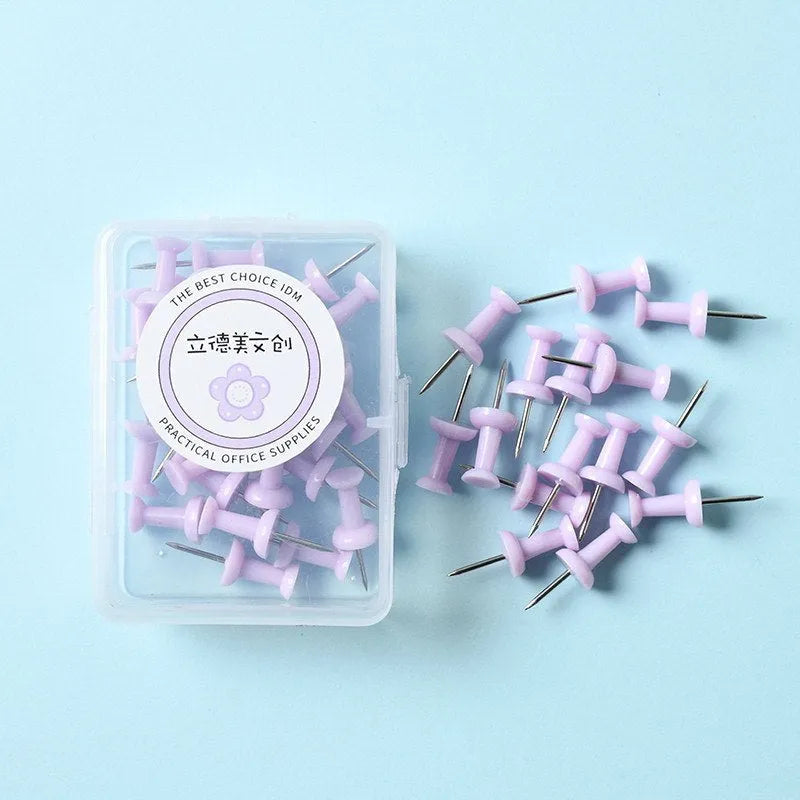 Plastic push pins in cherry blossom pink, mint green, and lavender, showing large and small sizes on a corkboard