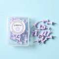Plastic push pins in cherry blossom pink, mint green, and lavender, showing large and small sizes on a corkboard