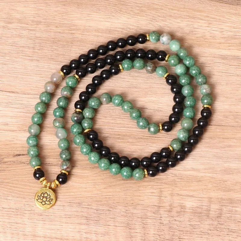 Green and black elastic beaded long bracelet with alloy construction shown on wrist