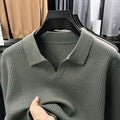 Man wearing a loose green pullover sweater, a casual autumn bottoming layer.