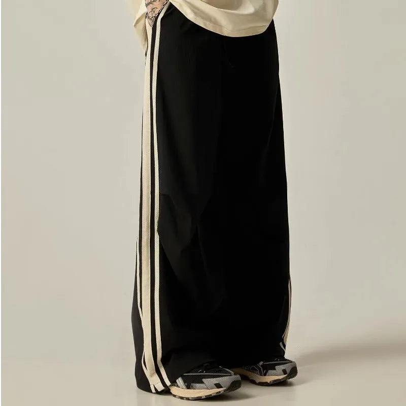 Black men's wide-leg high-waist climbing trousers laid flat, showing straight cut and polyester fabric.