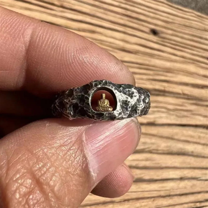 Close-up of a hand-forged copper Grotto Buddha ring with a rough rock texture on a size 8 finger.