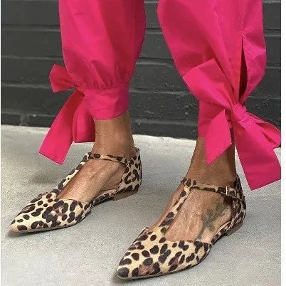 Leopard print women's court shoes with a pointed toe, cross shoulder strap, and a low chunky heel.