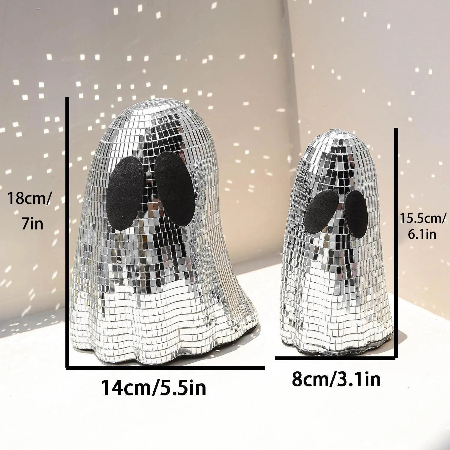 Silver glass Halloween ghost ornament with mosaic inlaid surface on a desktop.