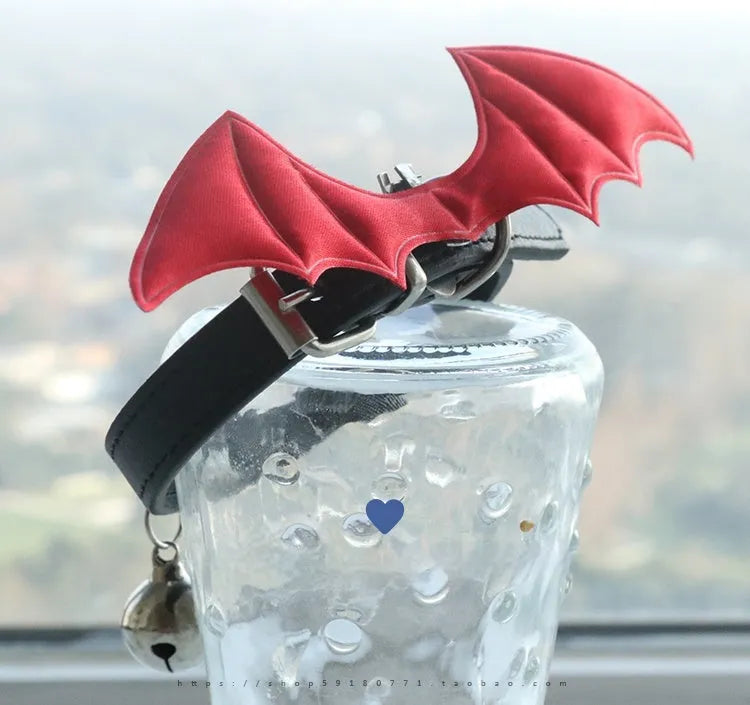 Leather dog collar with split devil wings design and bell attachment in patent leather satin material