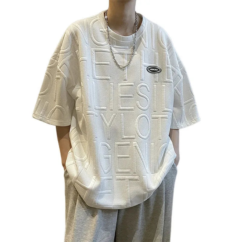 Men's grey short sleeve T-shirt with a raised 3D letter pattern, shown in a loose retro fit.