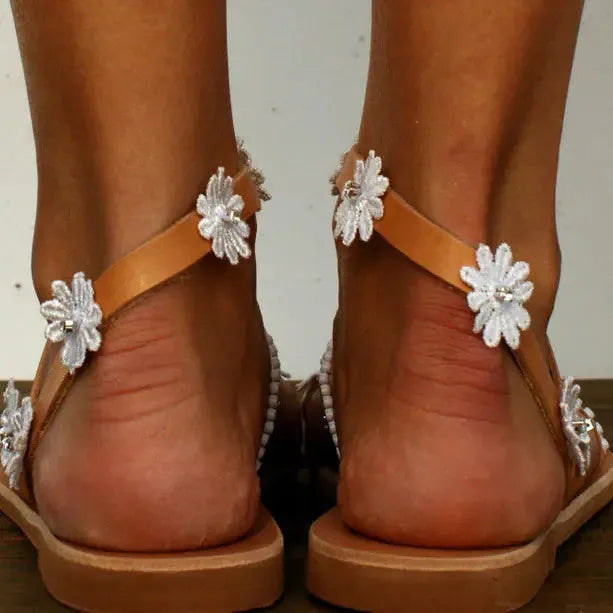 Brown ladies Roman sandals with flower pattern and flat rubber sole