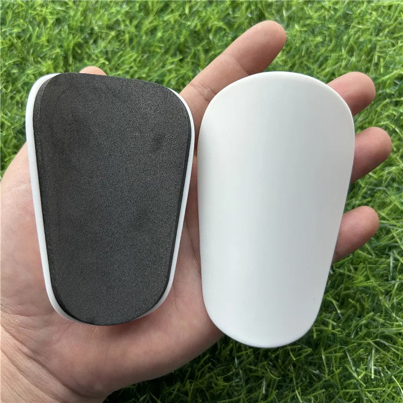 Pair of extra small black plastic football shin guards for junior players.
