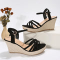 Women's black wedge sandals with fabric upper and fish mouth toe opening.