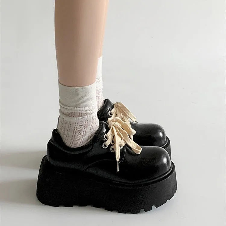 Women's matte black lace-up heeled shoes with thick rubber sole and block heel on a plain background
