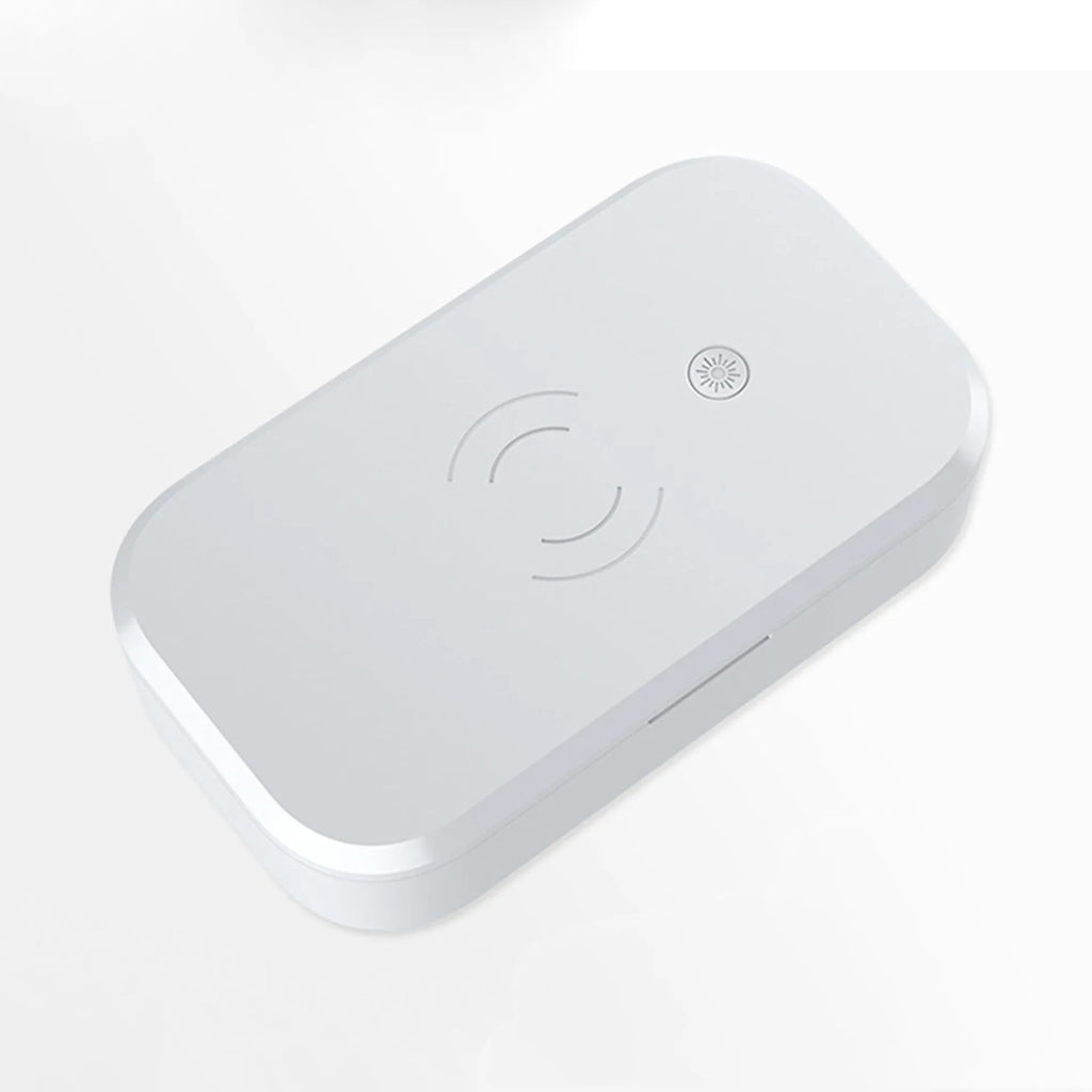 White multifunctional UV disinfection box with wireless charging pad for mobile phones and nail tools.