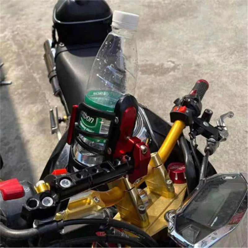 Modified black water bottle cage for Honda X-ADV scooter on handlebars.