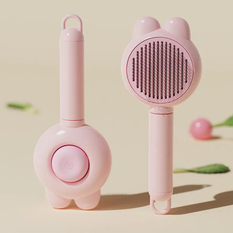 Green pet grooming brush with a self-cleaning button and a stainless steel comb.