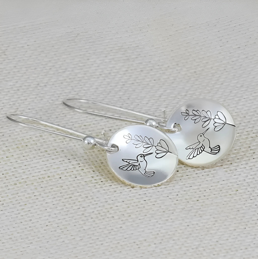 Silver round women's earrings with glossy finish showing bird and floral retro design details