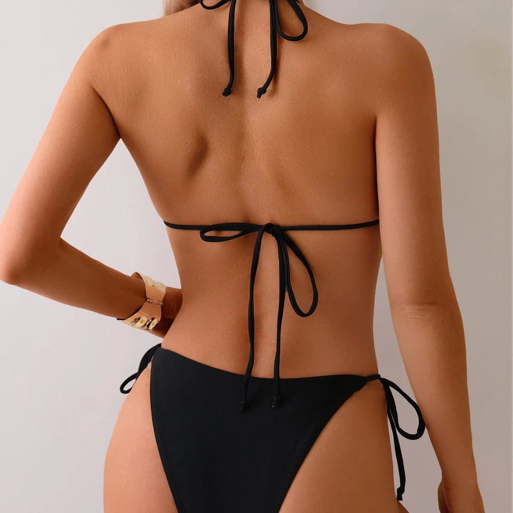 Black women's two-piece bikini swimsuit with metal bead detailing and split-style bottoms.