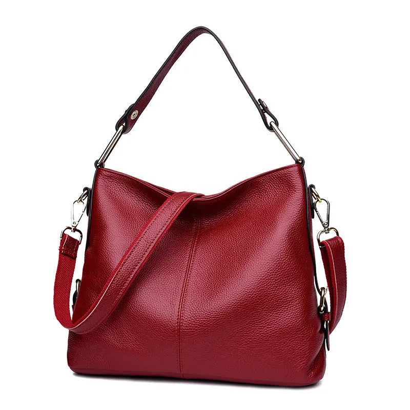 Genuine leather crossbody bag in a vertical square shape with visible sewing lines and a crossbody strap.