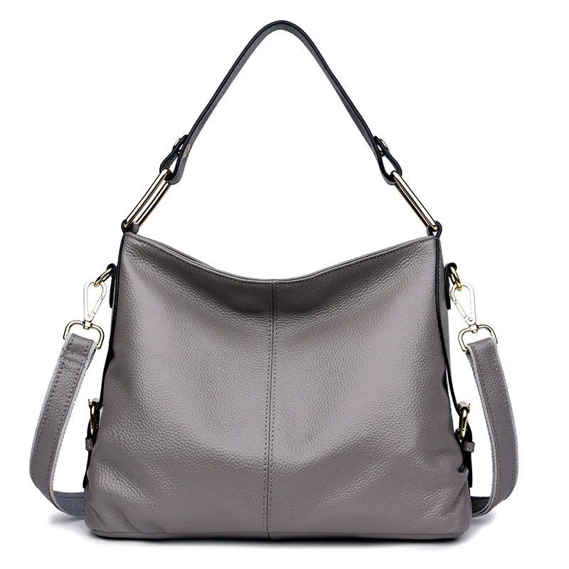 Genuine leather crossbody bag in a vertical square shape with visible sewing lines and a crossbody strap.