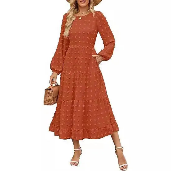 A woman wearing a beige high waist long sleeve dress with ruffled sleeves, a round neck, and a solid colour design.