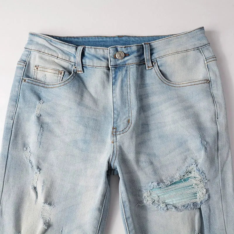 Men's light blue distressed slim fit jeans with five pocket patchwork, enzyme washed, side view