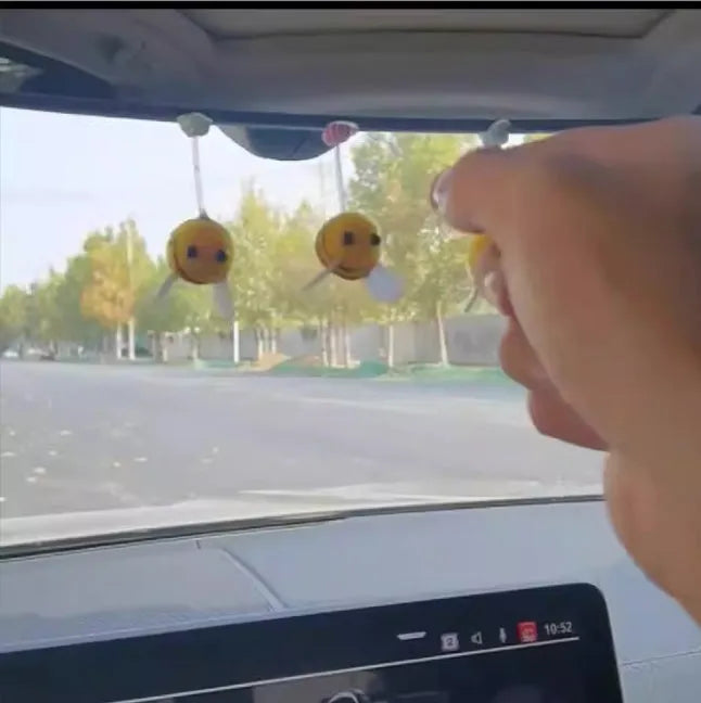 Small yellow and black fur ball bee car ornament with adhesive backing.