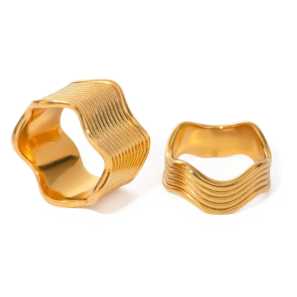 Stainless steel wide band ring with an embossed geometric wave pattern, shown in an electroplated colour.