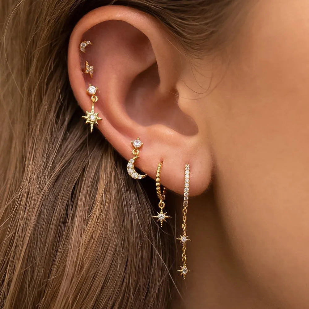 XINGX gold chain tassel earrings set with zircon stud accents, six individual pieces shown