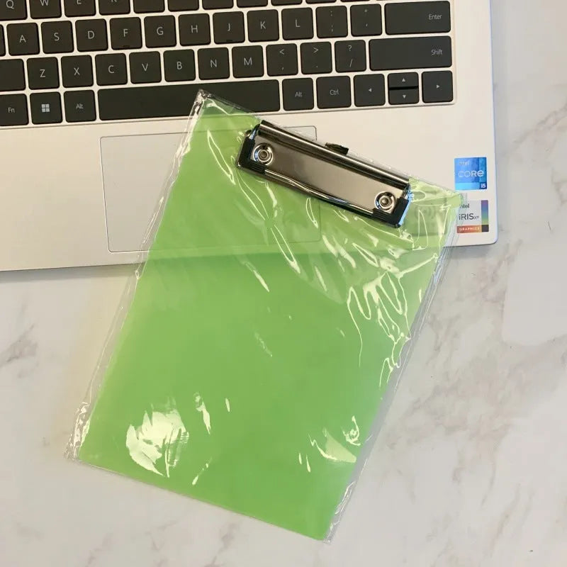 Transparent A4 plate writing board holder with metal clip, shown in blue colour on a desk.