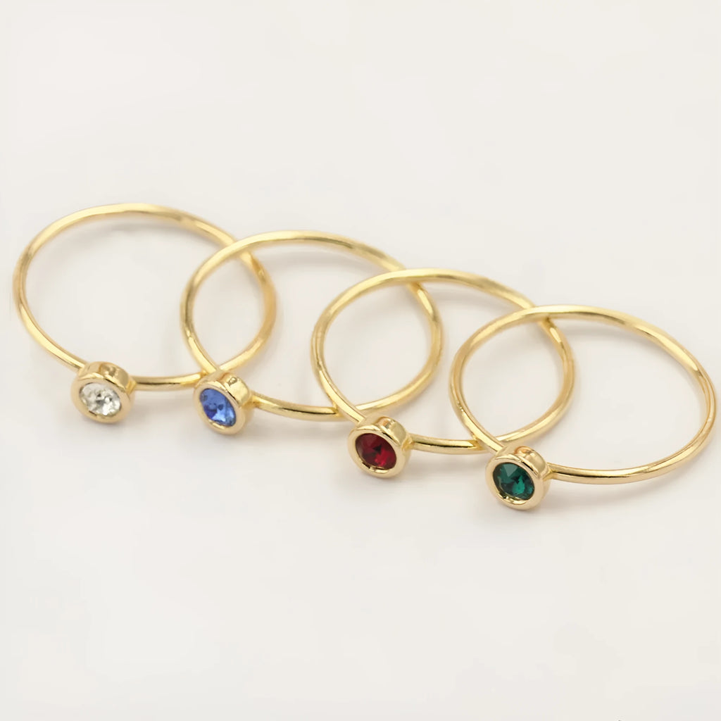 Women's 14K gilded copper knuckle ring with zircon accents in green, shown on a model's finger.