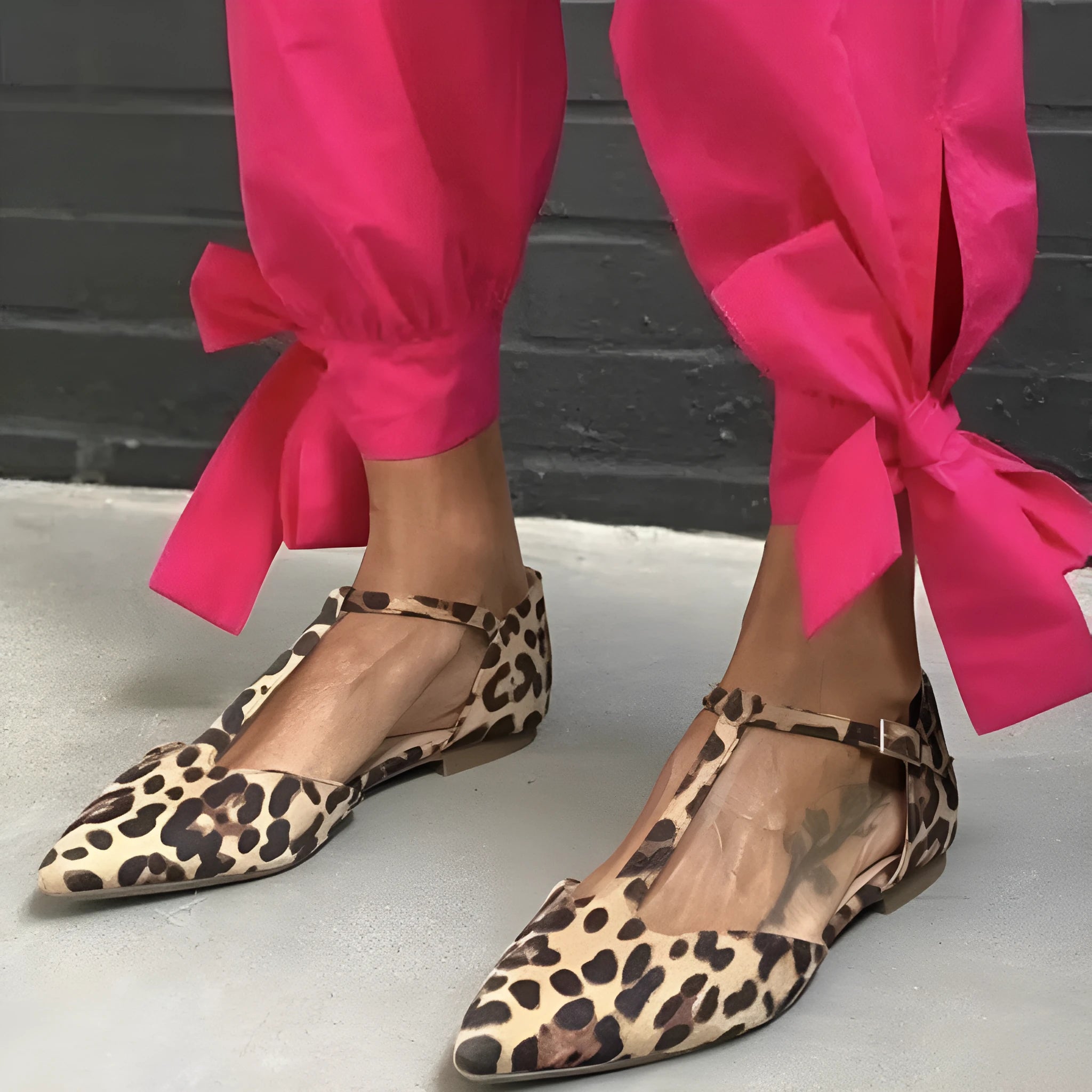 Leopard print women's court shoes with a pointed toe, cross shoulder strap, and a low chunky heel.