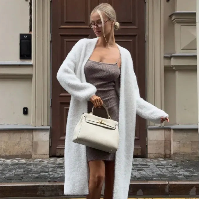 Women's long white knitted cardigan jacket with long sleeves shown open.