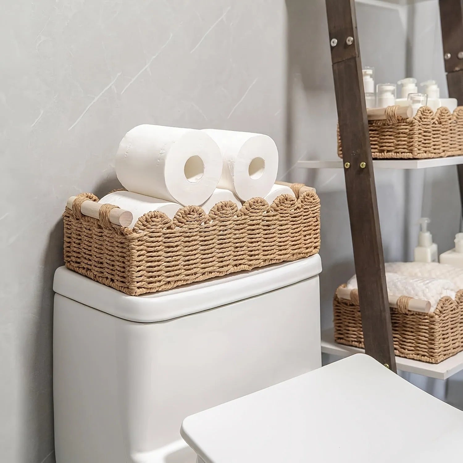 A minimalist woven paper storage basket in khaki colour on a wooden table, holding remote controls and pens.