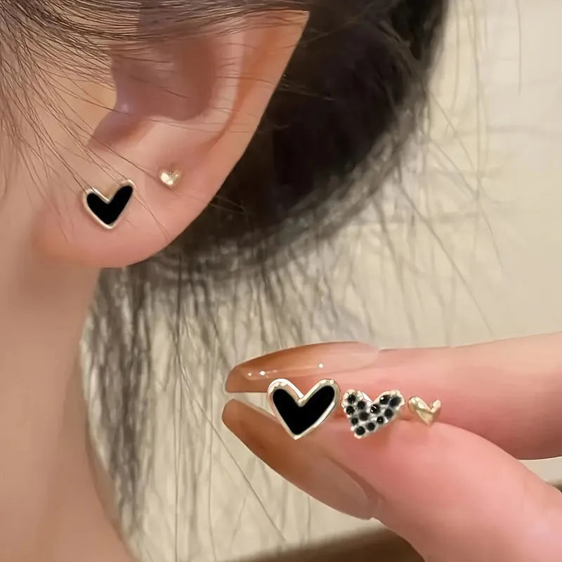 Three pairs of heart-shaped alloy earrings with electroplated finish in gold, black, and pink colours