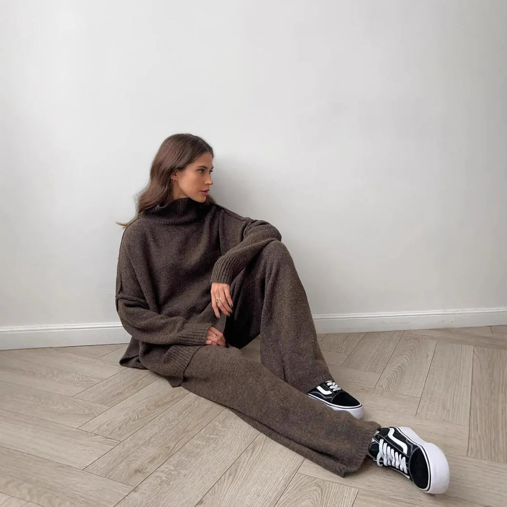 Women's dark grey acrylic knit sweater and trouser suit with a side-slit design on the top.