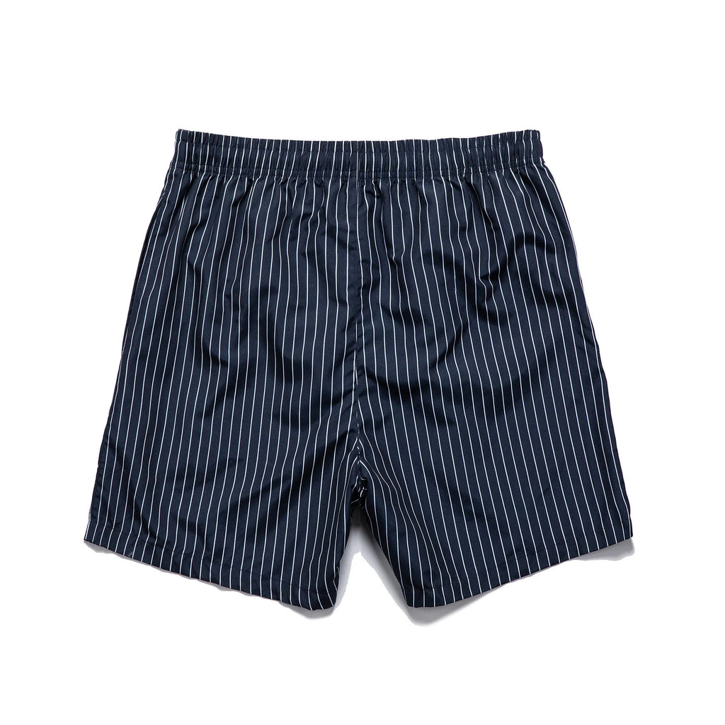 Man wearing grey striped polyester beach shorts with a straight leg opening