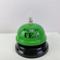 Iron table serving bell in multiple colour options on a wooden surface.