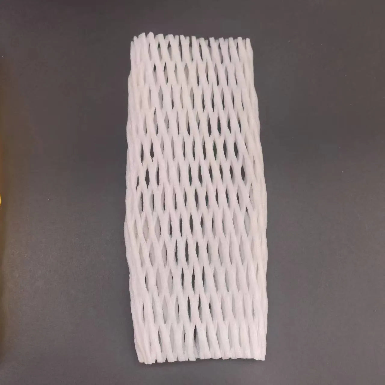 White foam protective net sleeves for fruit in assorted sizes on a table.
