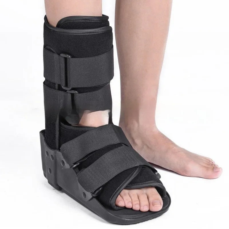 Grey achilles tendon rehabilitation boot with adjustable straps and a rigid plastic shell on a rubber sole.