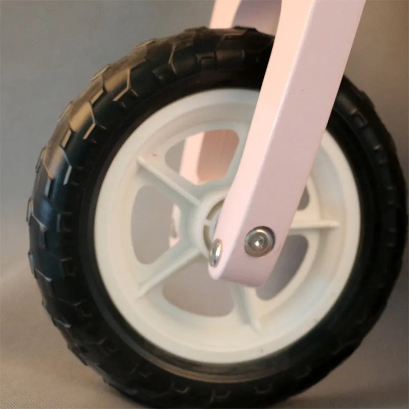 Pink wooden balance scooter for toddlers and young children on a 10-inch wooden deck.
