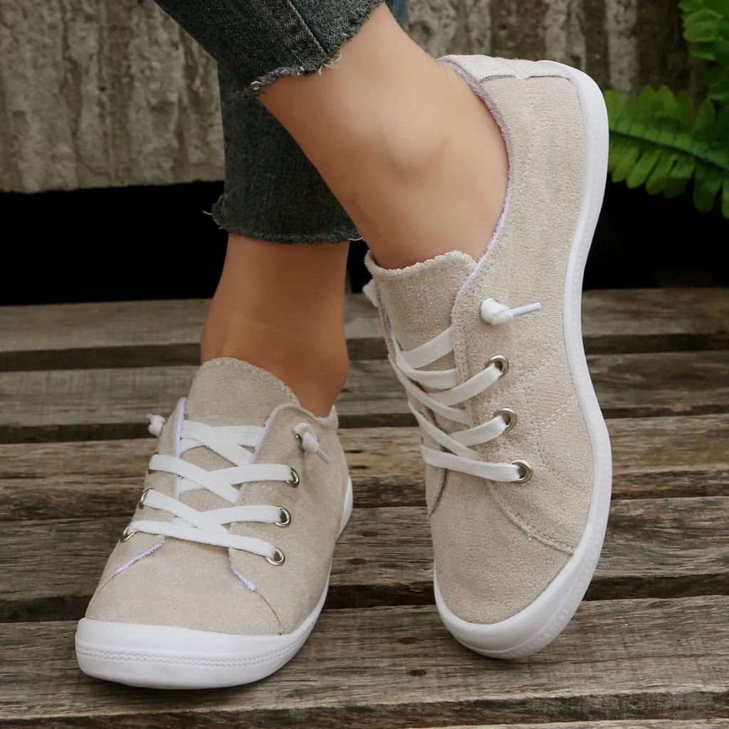 Creamy white low-top women's casual sneakers with a fabric upper and rubber sole.