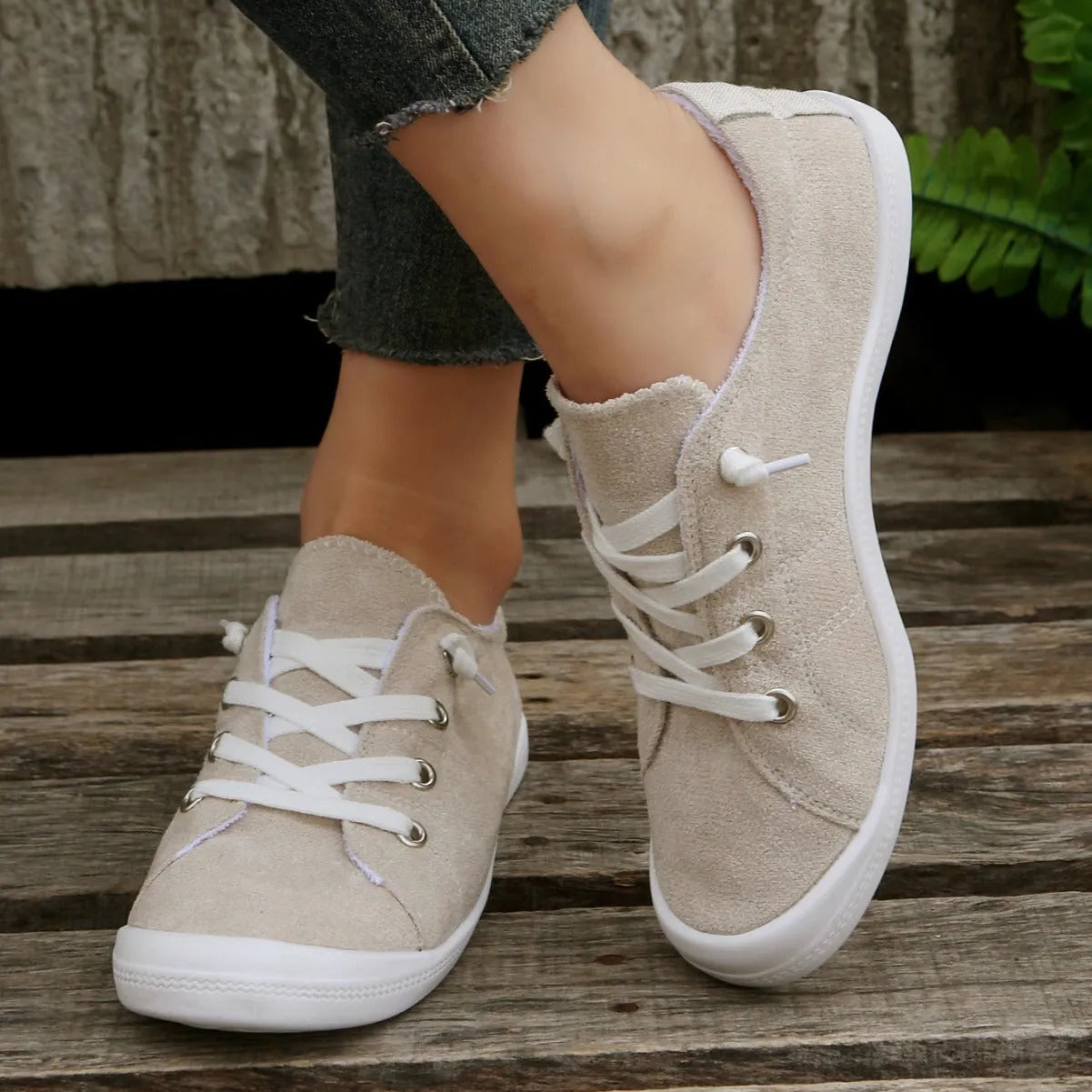 Creamy white low-top women's casual sneakers with a fabric upper and rubber sole.