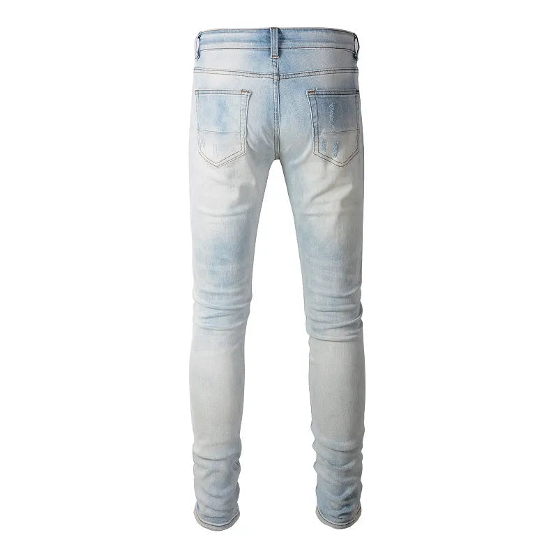 Men's light blue distressed slim fit jeans with five pocket patchwork, enzyme washed, side view
