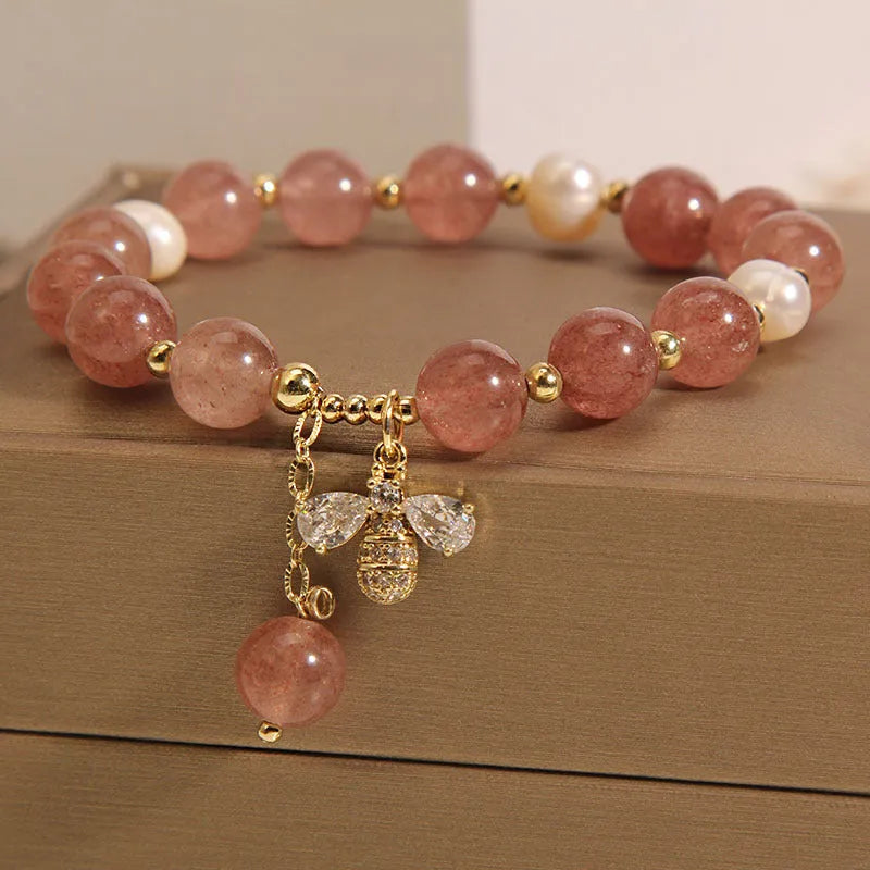 Women's bracelet with freshwater pearls, pink strawberry quartz stones, and a metallic zircon alloy clasp.