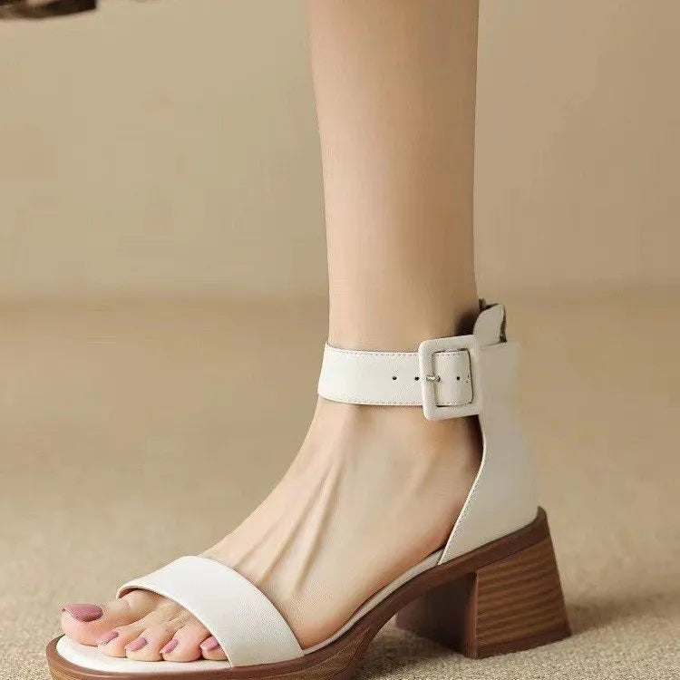 White women's platform high heels with an ankle strap and round toe on a plain background.