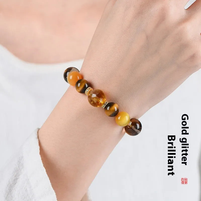 Close-up of a yellow artificial crystal beaded bracelet with 10mm Jinba beads on a wrist.