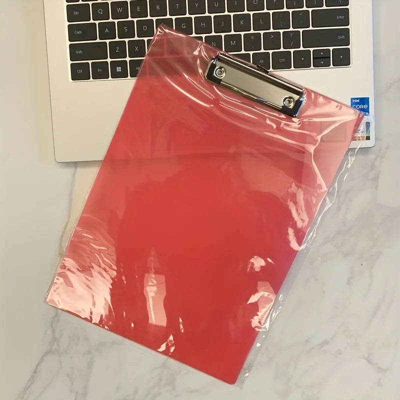 Transparent A4 plate writing board holder with metal clip, shown in blue colour on a desk.