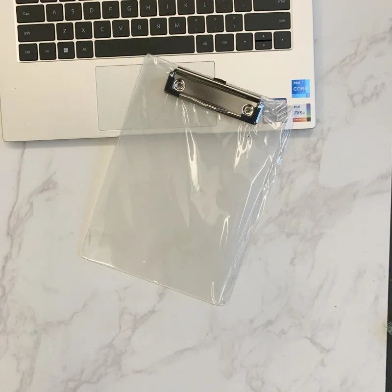 Transparent A4 plate writing board holder with metal clip, shown in blue colour on a desk.